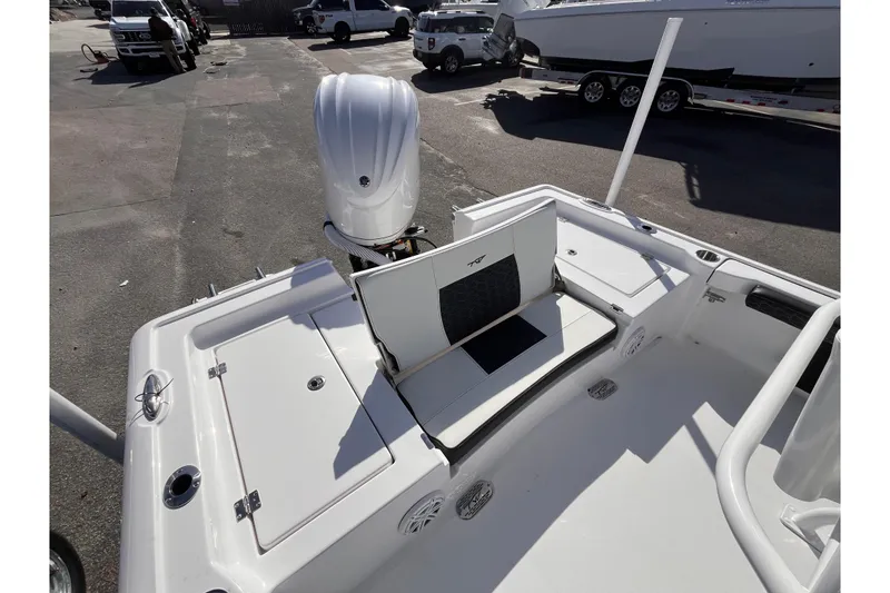 Slide: The Image of 2026 Tidewater 2300 Carolina Bay boat interior with seating and motor, parked outdoors. - 6