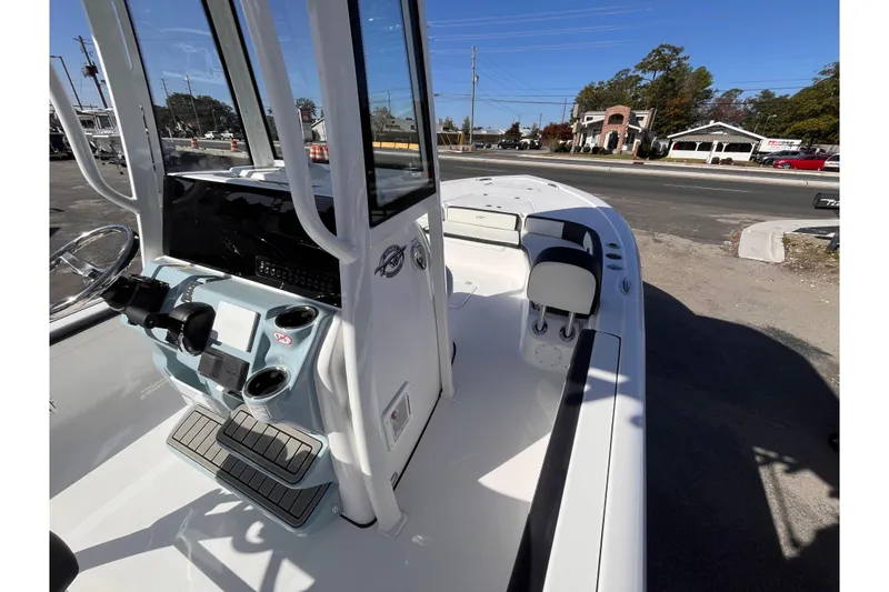 Slide: The Image of 2026 Tidewater 2300 Carolina Bay boat interior with console and seating, parked outdoors. - 9