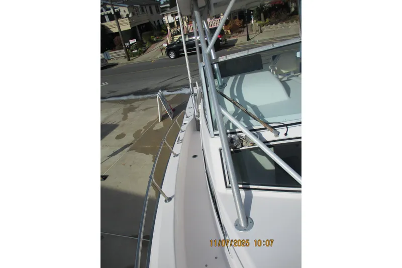 Slide: The Image of 1996 Grady-White Sailfish 272 boat docked, showing deck and railing details. - 14