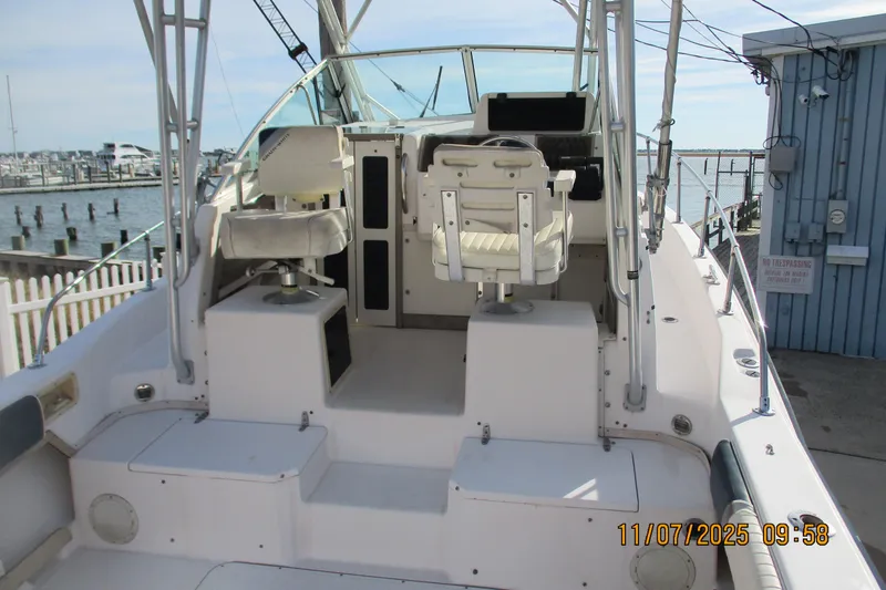 Slide: The Image of 1996 Grady-White Sailfish 272 boat interior with helm and seating, docked by the marina. - 25