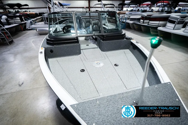 Slide: The Image of 2026 Lund 1700 Explorer Sport boat displayed in a showroom with sleek design. - 13