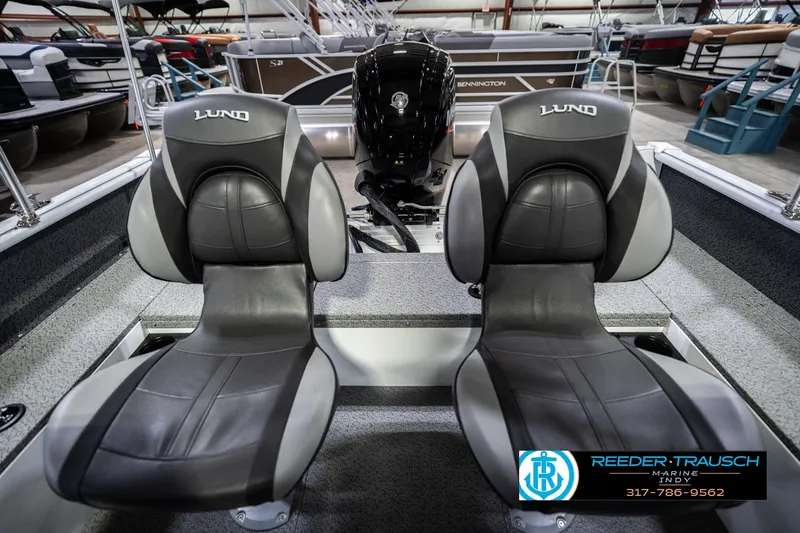 Slide: The Image of 2026 Lund 1700 Explorer Sport boat interior with dual seats and motor, displayed at Reeder-Trausch Marine. - 21