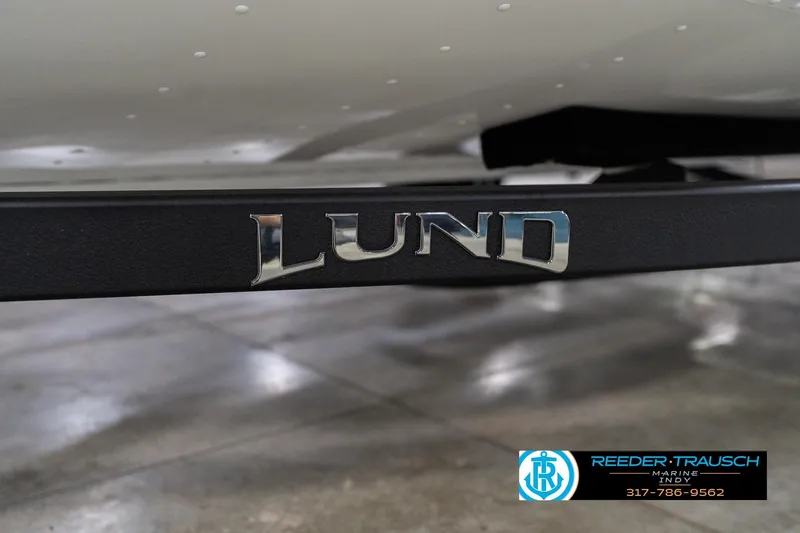 Slide: The Image of 2026 Lund 1700 Explorer Sport boat trailer with logo, displayed indoors. - 58