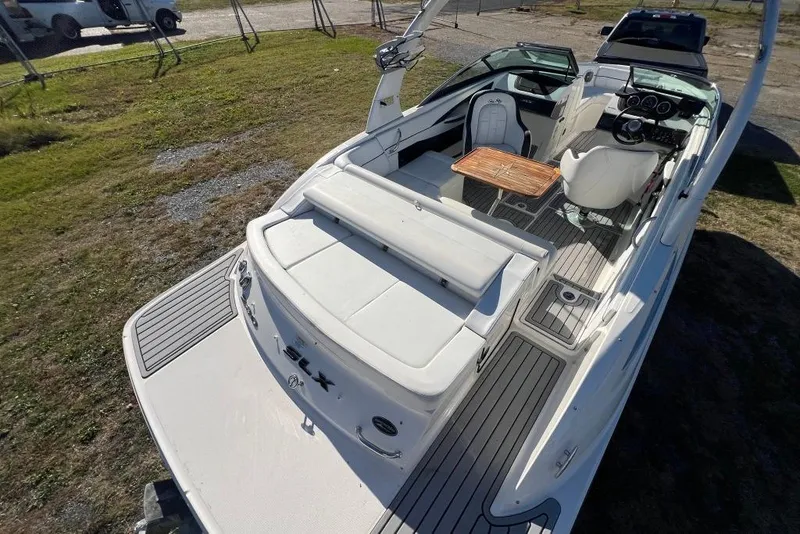 Slide: The Image of 2016 Sea Ray 230 SLX boat interior with seating and wooden table. - 14