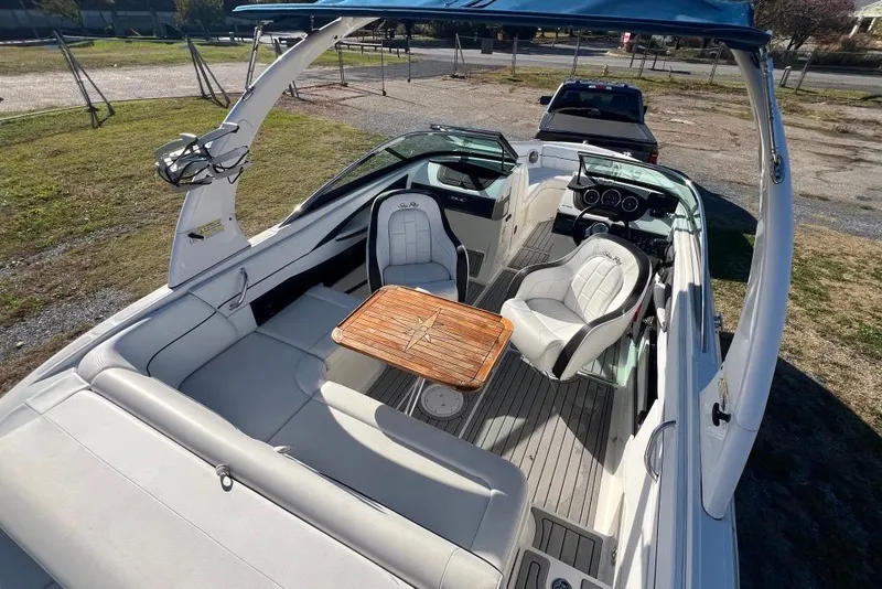 Slide: The Image of 2016 Sea Ray 230 SLX boat interior with seating and wooden table. - 15