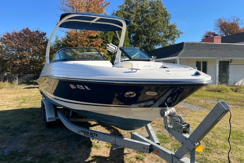 Slide: The Image of 2016 Sea Ray 230 SLX boat on trailer, parked outdoors near a house. - 27