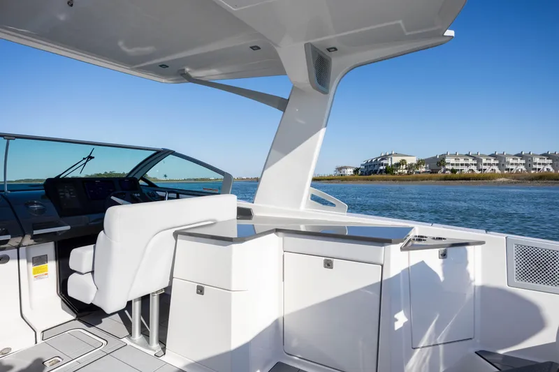 Slide: The Image of 2023 Aviara AV32 OB boat interior with sleek design, overlooking calm waters and distant buildings. - 18