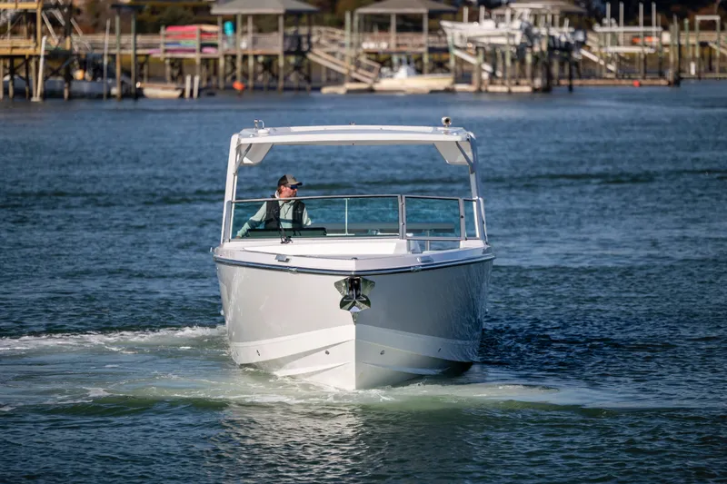 Slide: The Image of 2023 Aviara AV32 OB boat cruising on a calm waterfront near docks. - 6