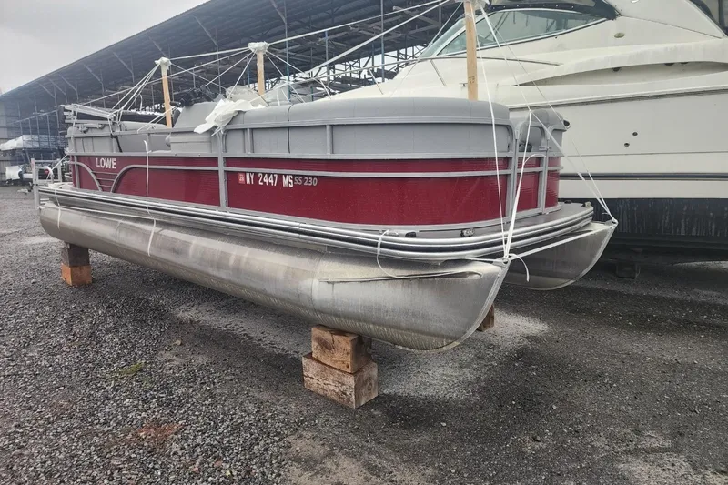 Slide: The Image of Colorful chairs by a lakeside dock with a 2021 Lowe SS 230 WT boat. - 1