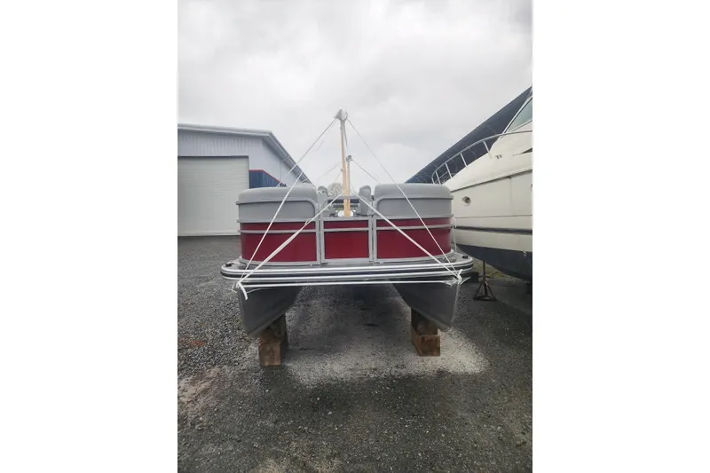 Slide: The Image of 2021 Lowe SS 230 WT pontoon boat on wooden blocks, near industrial building. - 3