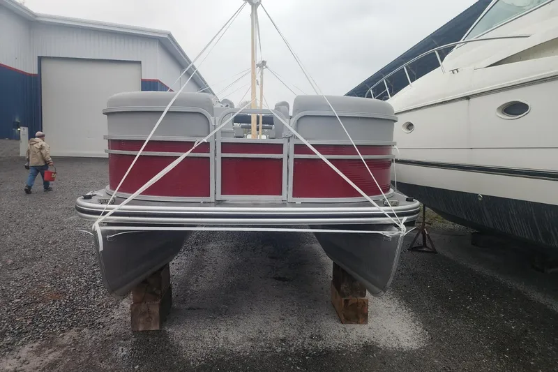 Slide: The Image of 2021 Lowe SS 230 WT pontoon boat on gravel lot, secured with ropes. - 6