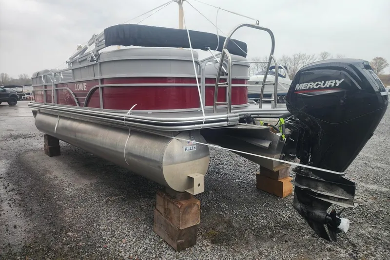 Slide: The Image of 2021 Lowe SS 230 WT pontoon boat on wooden blocks, outdoor storage. - 7