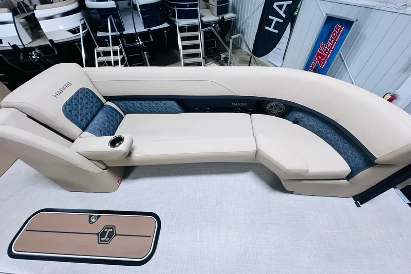 Slide: The Image of Luxurious seating on 2025 Harris Solstice 250 boat, featuring beige and blue upholstery. - 10