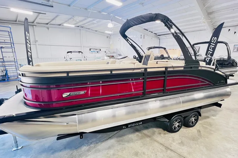 Slide: The Image of 2025 Harris Solstice 250 pontoon boat in showroom, featuring sleek red design and modern amenities. - 3