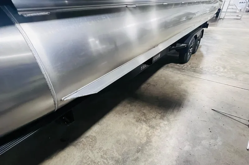 Slide: The Image of 2025 Harris Solstice 250 pontoon boat on trailer in a garage setting. - 65