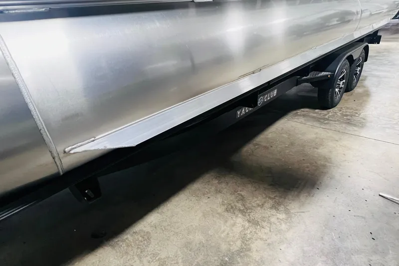 Slide: The Image of 2025 Harris Solstice 250 pontoon boat on trailer in a garage setting. - 66