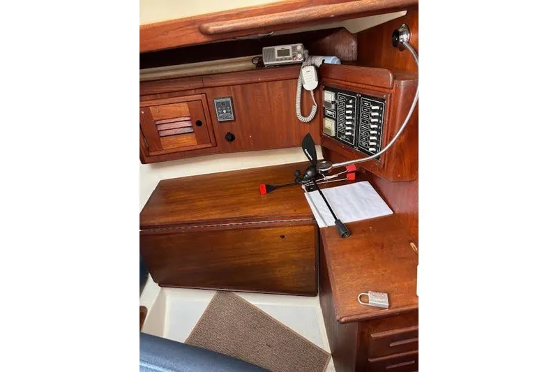Slide: The Image of 1988 Tartan 31 Cutter Rigged Masthead Sloop navigation station with wooden cabinetry and control panel. - 23