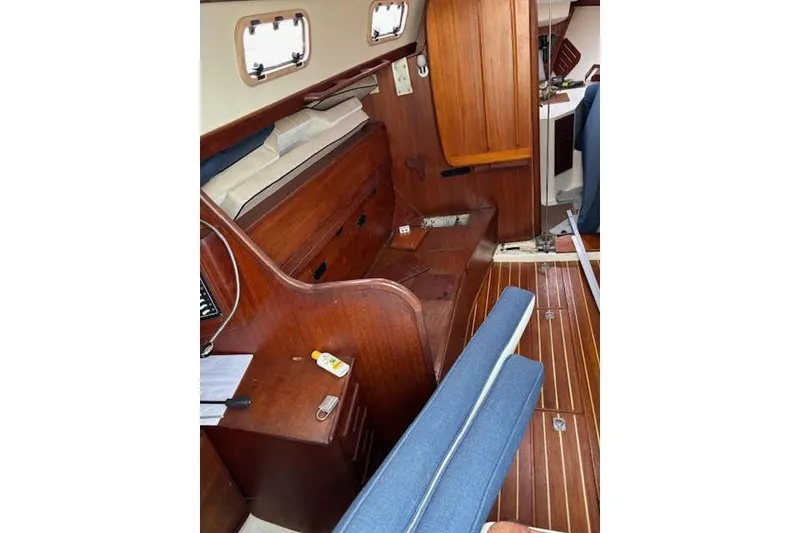 Slide: The Image of 1988 Tartan 31 Cutter Rigged Masthead Sloop interior with wooden finish and blue cushions. - 24