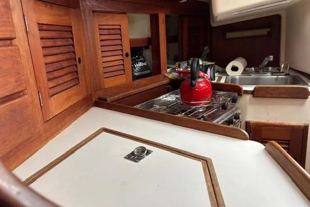 Slide: The Image of Interior of 1988 Tartan 31 Cutter Rigged Masthead Sloop with wooden cabinets and red kettle. - 36