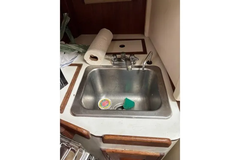 Slide: The Image of Galley sink in 1988 Tartan 31 Cutter Rigged Masthead Sloop, with faucet and cleaning supplies. - 37