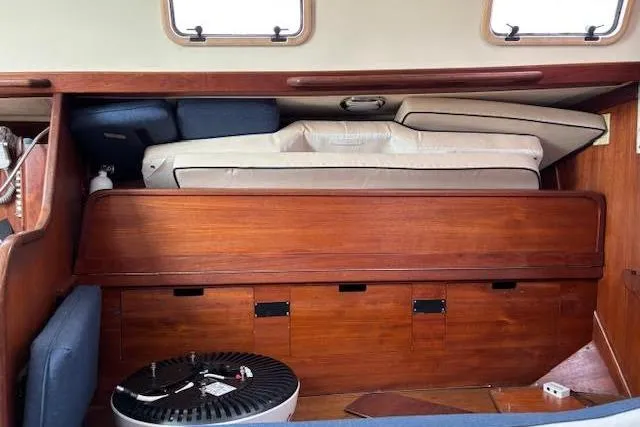 Slide: The Image of Interior of 1988 Tartan 31 Cutter Rigged Masthead Sloop with wooden storage and cushions. - 39