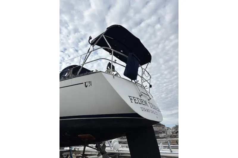 Slide: The Image of 1988 Tartan 31 Cutter Rigged Masthead Sloop docked under cloudy sky. - 4