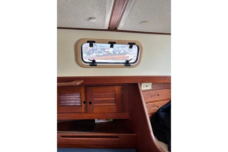 Slide: The Image of Interior of 1988 Tartan 31 Cutter Rigged Masthead Sloop with wooden cabinetry and porthole. - 40