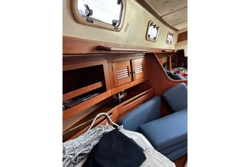 Slide: The Image of Interior of 1988 Tartan 31 Cutter Rigged Masthead Sloop with wooden cabinetry and blue cushions. - 41