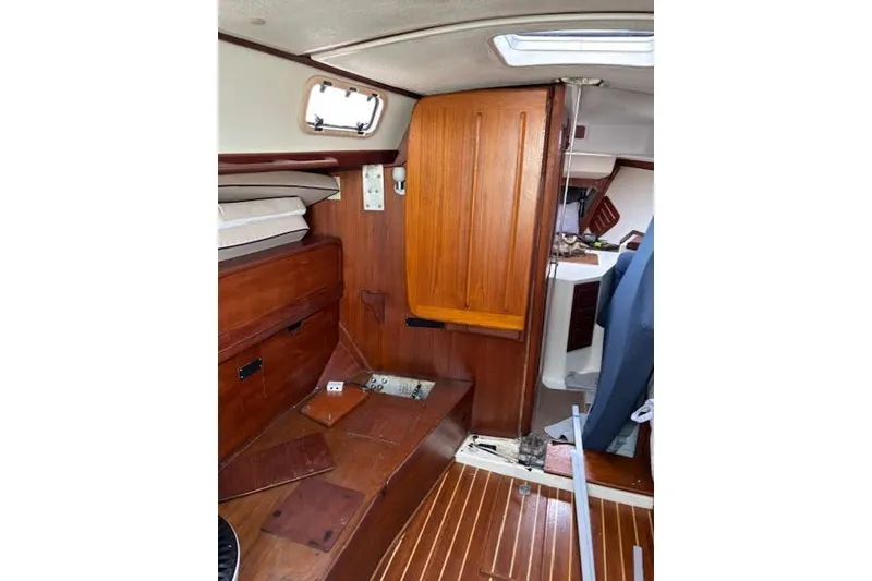 Slide: The Image of Interior of 1988 Tartan 31 Cutter Rigged Masthead Sloop, featuring wooden cabinetry and seating. - 46