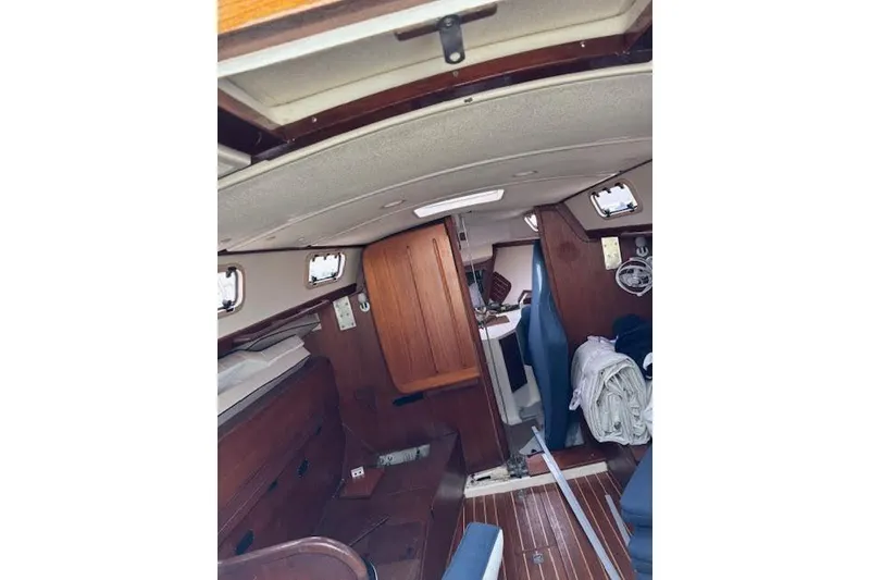 Slide: The Image of Interior of 1988 Tartan 31 Cutter Rigged Masthead Sloop, featuring wood paneling and seating. - 48