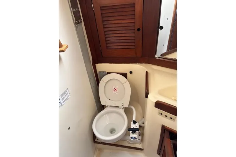 Slide: The Image of 1988 Tartan 31 Cutter Rigged Sloop bathroom with toilet and wooden cabinet. - 52