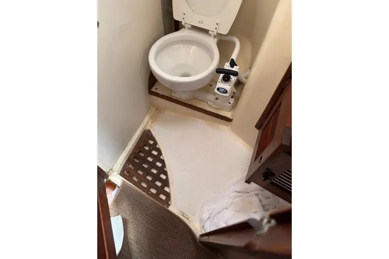 Slide: The Image of 1988 Tartan 31 Cutter Rigged Sloop bathroom with marine toilet and wooden cabinet. - 53