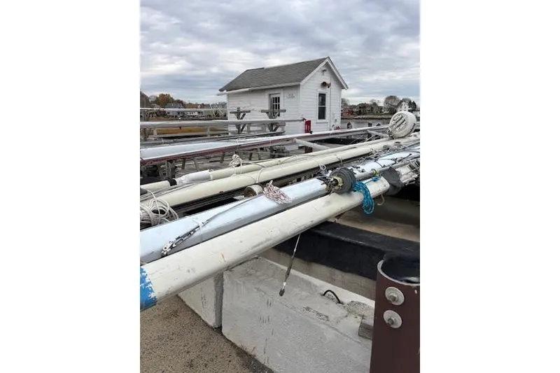 Slide: The Image of 1988 Tartan 31 Cutter Rigged Masthead Sloop mast on dock, cloudy sky background. - 61
