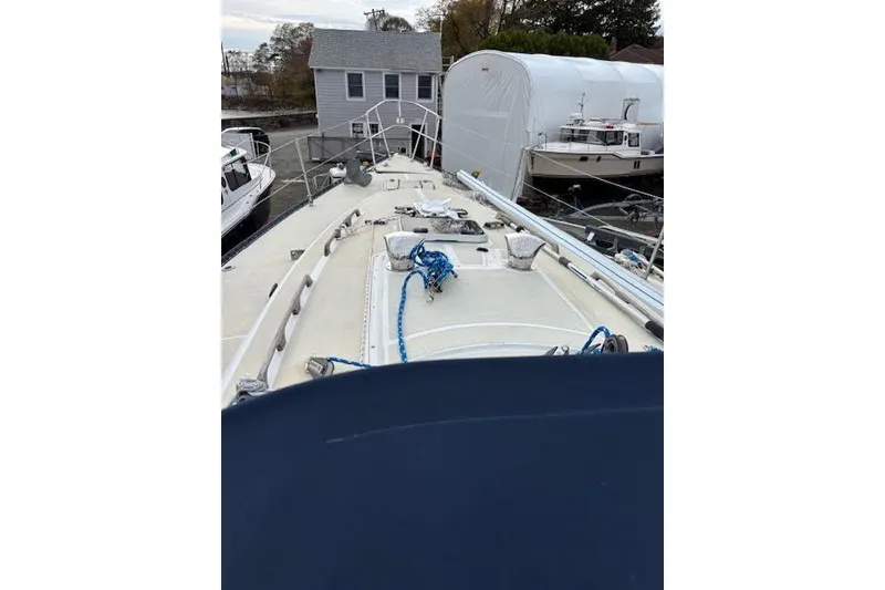 Slide: The Image of 1988 Tartan 31 Cutter Rigged Masthead Sloop on deck, docked near boats and buildings. - 7