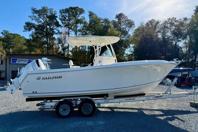 Slide: The Image of 2016 Sailfish 240 CC boat on trailer, parked outdoors with trees in background. - 36