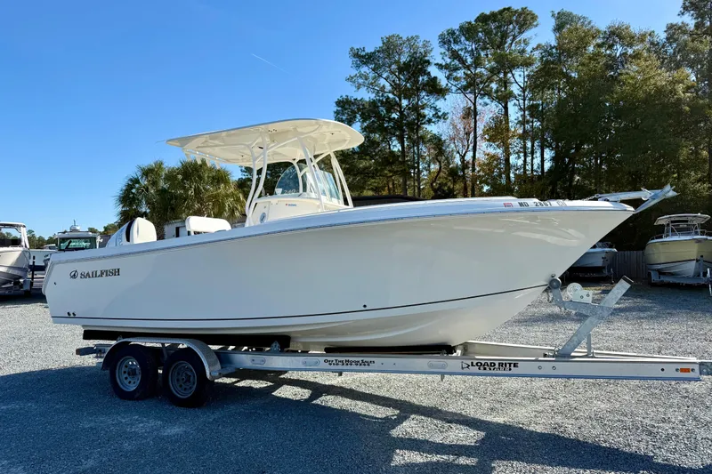 Slide: The Image of 2016 Sailfish 240 CC boat on trailer, parked outdoors with trees in background. - 37