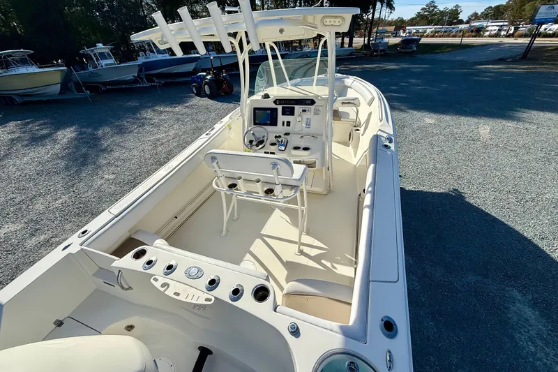 Slide: The Image of 2016 Sailfish 240 CC boat interior with helm, seating, and rod holders in a marina setting. - 44