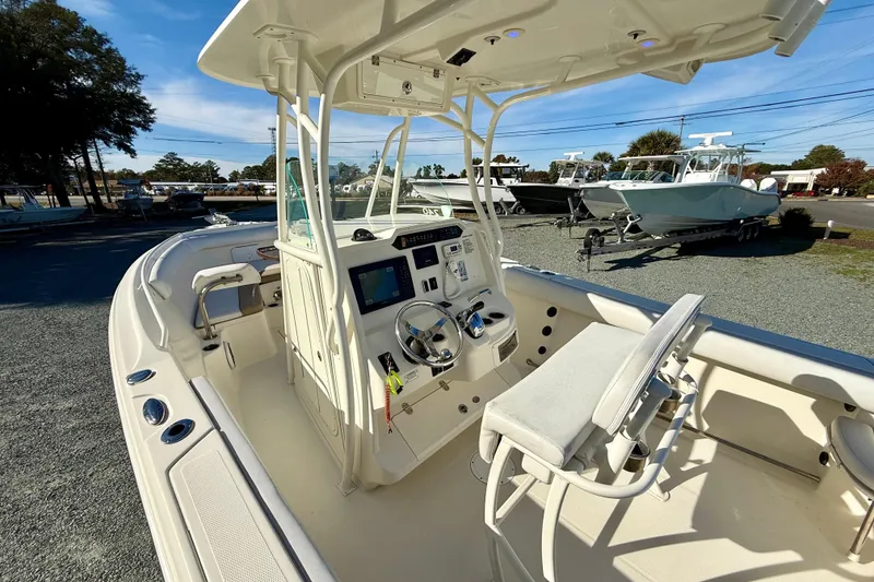Slide: The Image of 2016 Sailfish 240 CC boat interior with steering console and seating, displayed outdoors. - 46