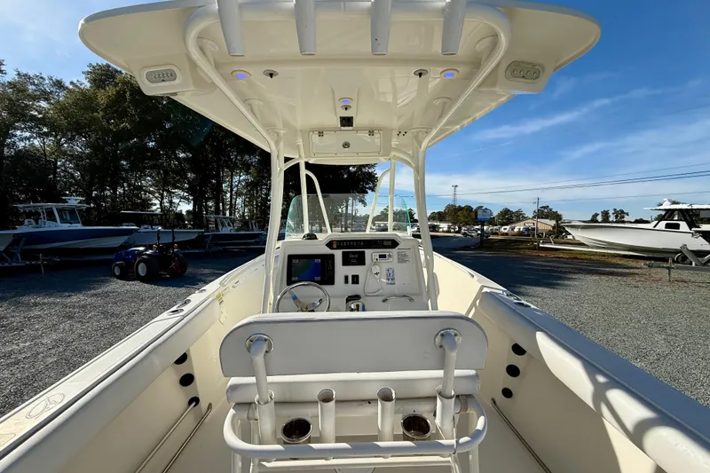 Slide: The Image of 2016 Sailfish 240 CC boat interior with console and seating, parked outdoors. - 47