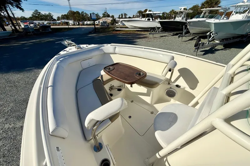 Slide: The Image of 2016 Sailfish 240 CC boat interior with seating and table, parked in a marina. - 54