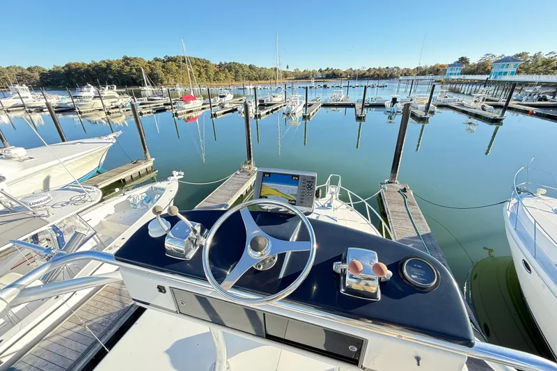 Slide: The Image of Helm of 1996 Cabo 35 boat at marina, featuring steering wheel and controls. - 22