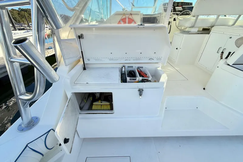 Slide: The Image of 1996 Cabo 35 boat interior with open storage compartments and fishing gear. - 31
