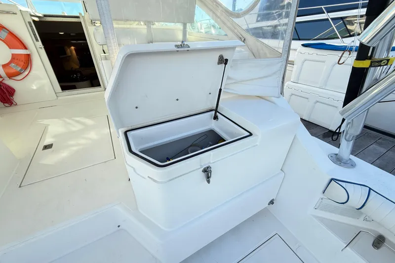 Slide: The Image of Open storage compartment on 1996 Cabo 35 boat deck, with visible life preserver nearby. - 32