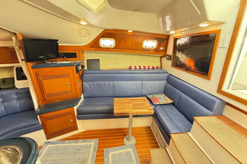 Slide: The Image of Interior of a 1996 Cabo 35 boat with cozy seating and wooden cabinetry. - 36