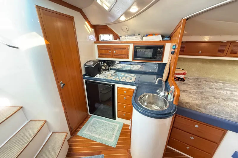 Slide: The Image of Interior of a 1996 Cabo 35 boat with blue seating and wooden accents. - 37