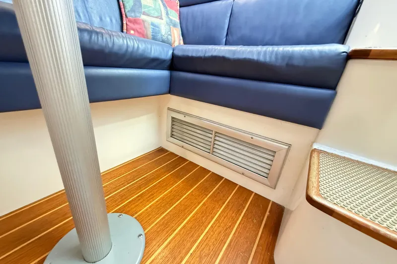 Slide: The Image of 1996 Cabo 35 boat deck with storage compartment and blue cushion. - 48