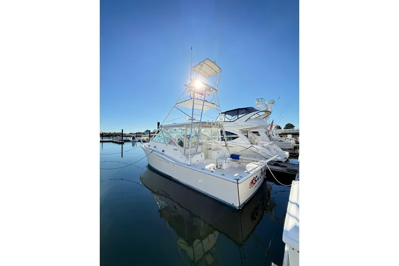 Slide: The Image of 1996 Cabo 35 boat docked at marina under clear blue sky. - 68