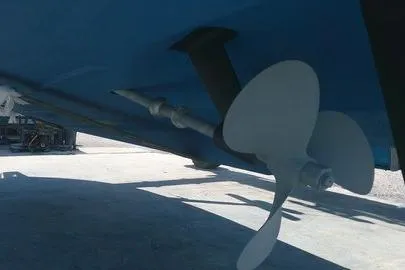 Slide: The Image of 1996 Cabo 35 boat in a marina, under maintenance, surrounded by other boats and structures. - 77