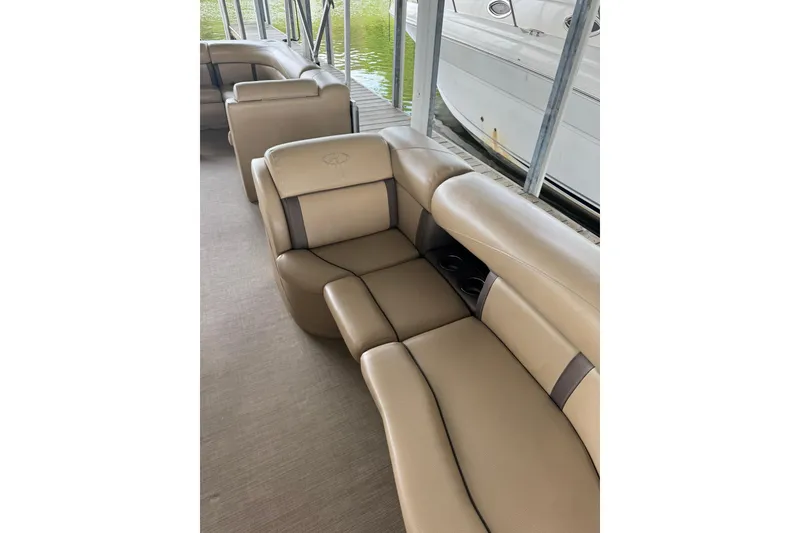Slide: The Image of Luxurious seating on a 2019 Harris CX 230 boat, docked beside a serene lake. - 4