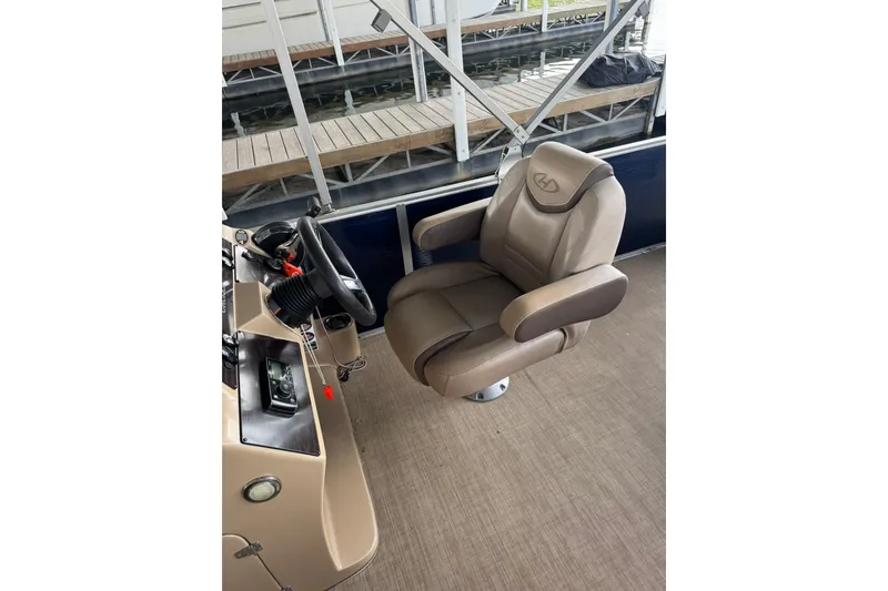 Slide: The Image of Captain's chair and helm of 2019 Harris CX 230 boat, dockside view. - 7